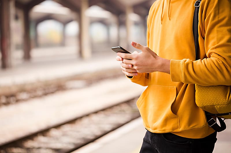 Uma pessoa a utilizar um smartphone em p&uacute;blico.